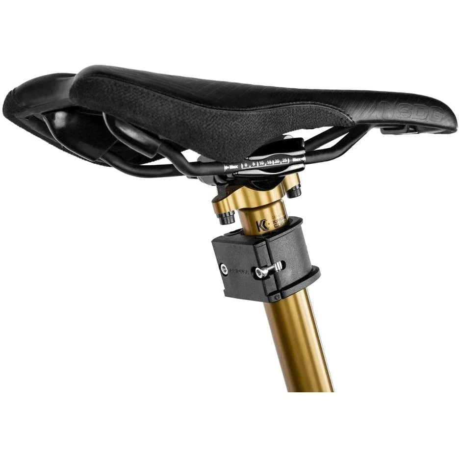 Apidura Dropper Post Adapter on a bike bar with a white background